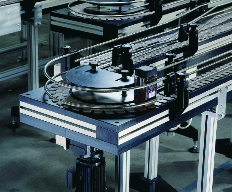Flat top chain conveyor carrying a can of instant coffee