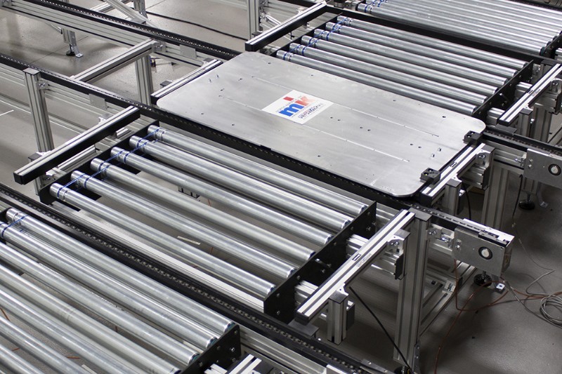 Over-sized pallet on roller and chain conveyors