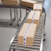 boxes on a stainless steel roller conveyor with curve