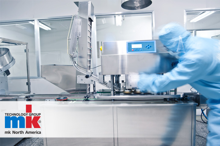 A worker using an mk conveyor system in a sterile cleanroom environment.