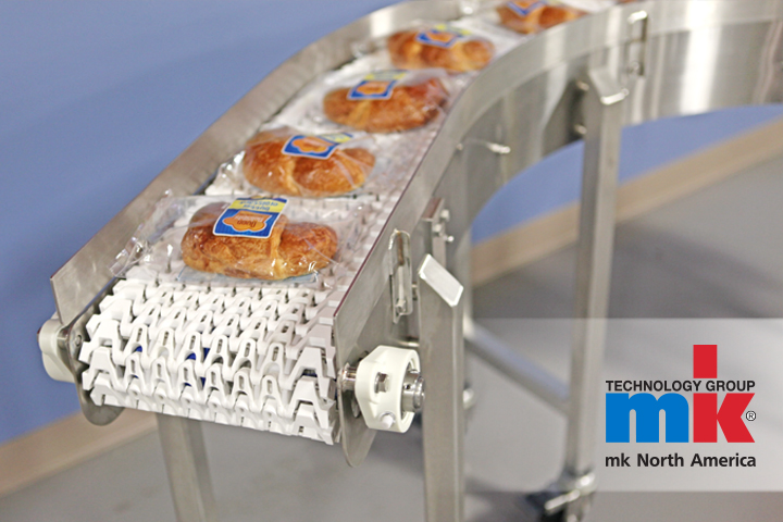 A modular plastic belt conveyor carrying a packaged food item - and example of conveyors in the packaging industry.