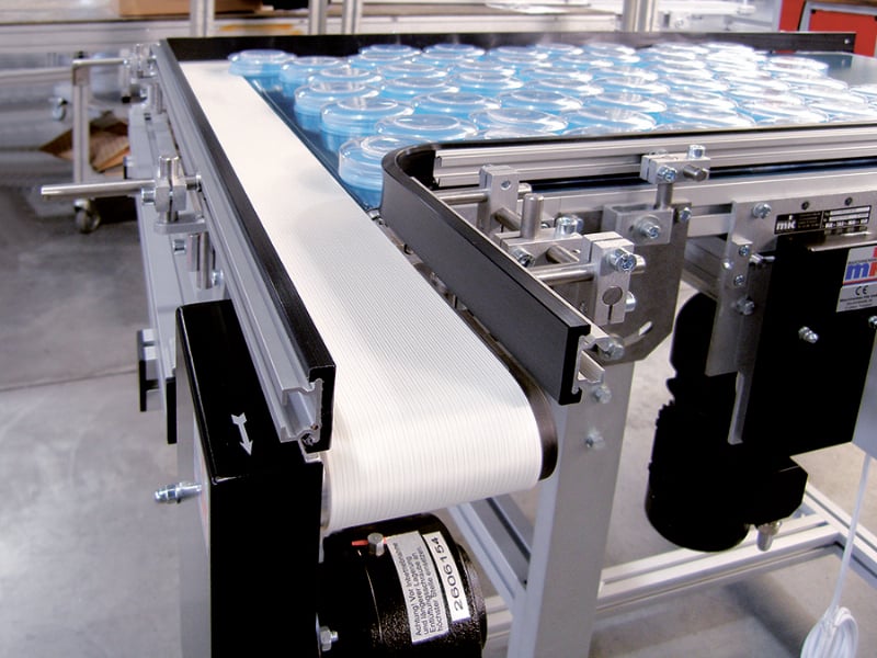 Two conveyors transferring plastic parts 90-degrees