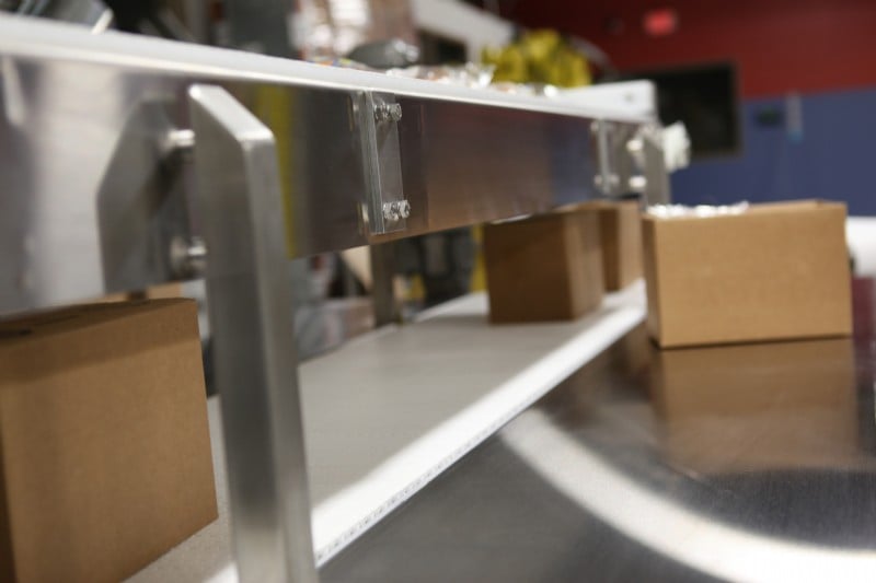 Two stacked stainless steel conveyors with table