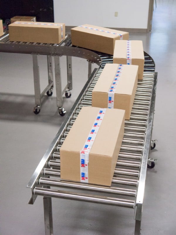 boxes on a stainless steel roller conveyor with curve