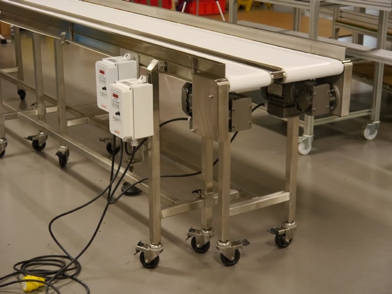 Two stainless steel conveyors with white belts