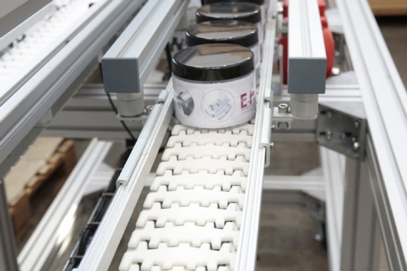 conveyor carrying lotion containers