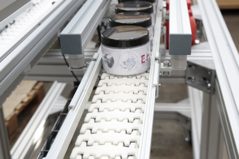 conveyor carrying lotion containers