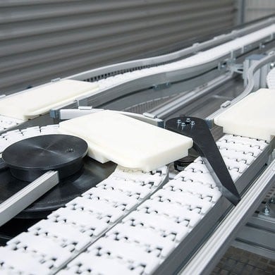 Small white pallet on flexible chain conveyor