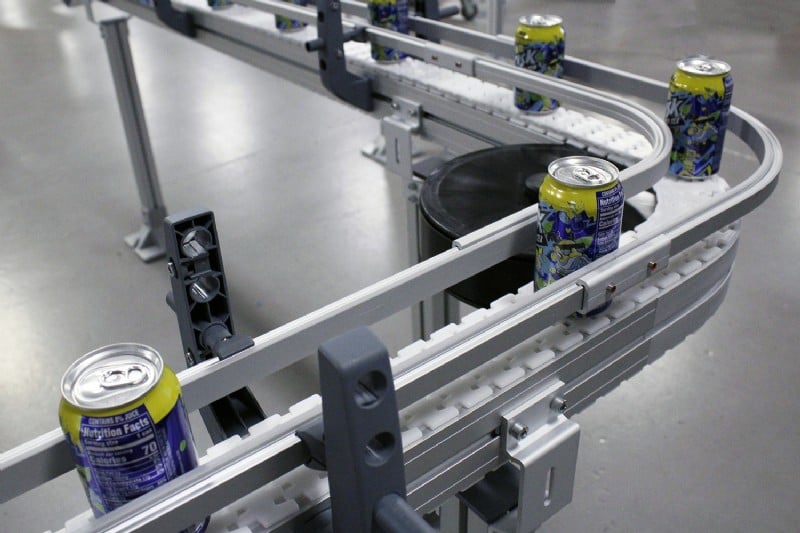 Table top chain conveyor carrying cans