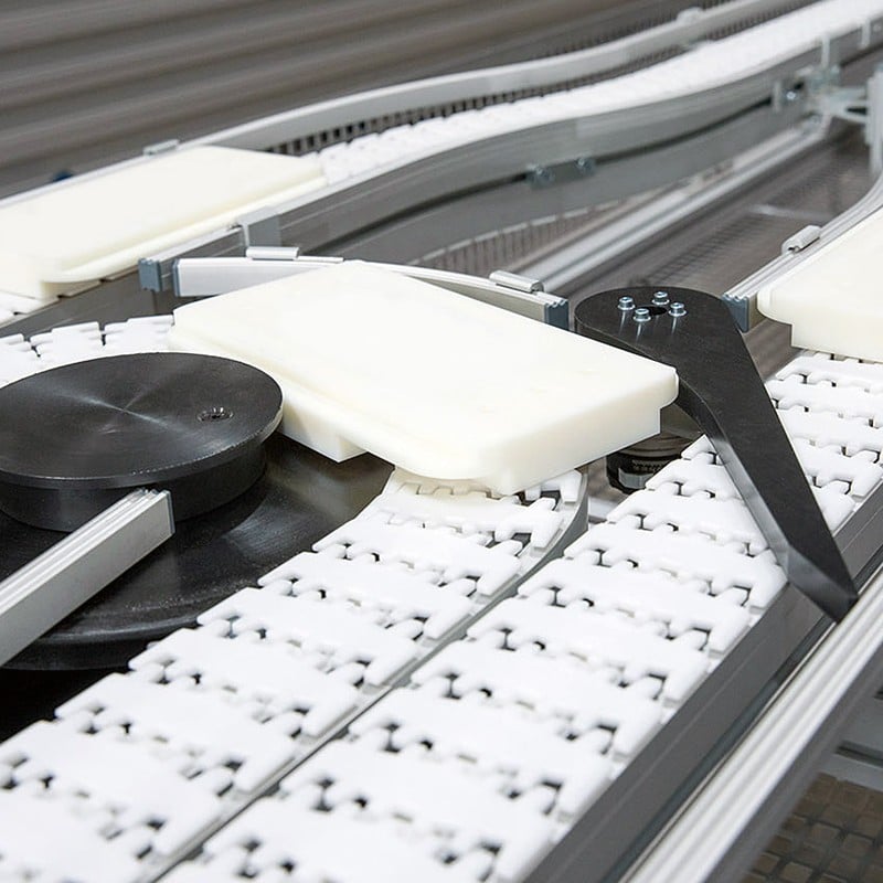 A pallet on a flat top chain conveyor with a gate