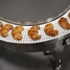 Hygienic conveyor carrying croissants.