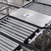 Pallet on a roller conveyor transfering to a chain conveyor