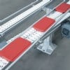 red pallets transfer between conveyors.