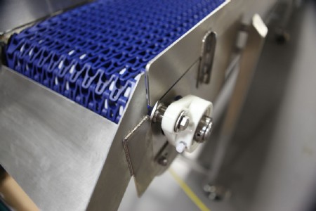 Photo detail of a blue plastic modular belt stainless steel conveyor with chute. 