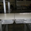 Two flat belt conveyors with rolling nose bars.
